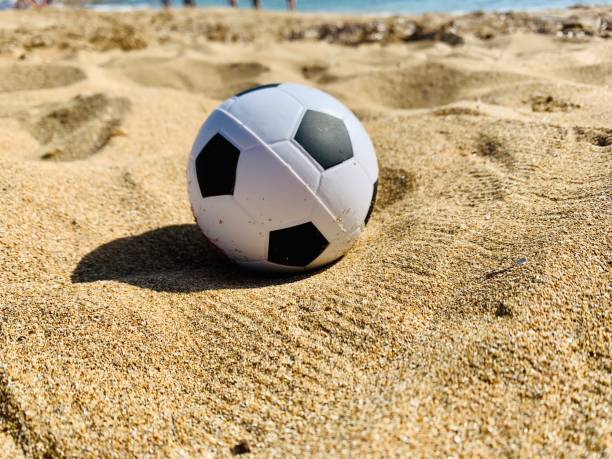 istock Soccer ball toy on sandy beach 1249213825