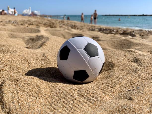 istock Soccer ball toy on sandy beach 1249213873