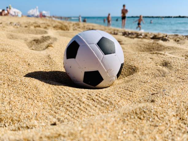 istock Soccer ball toy on sandy beach 1249213920