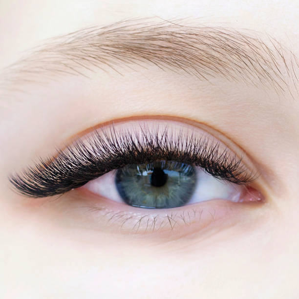 Eyelash extensions. Close-up of eyes with extended eyelashes of a white girl Eyelash extensions. Close-up of eye with extended eyelashes of a white girl false lashes stock pictures, royalty-free photos & images