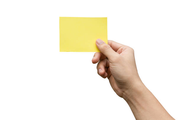 istock Hand holding yellow paper isolated on white with clipping path 1249219733