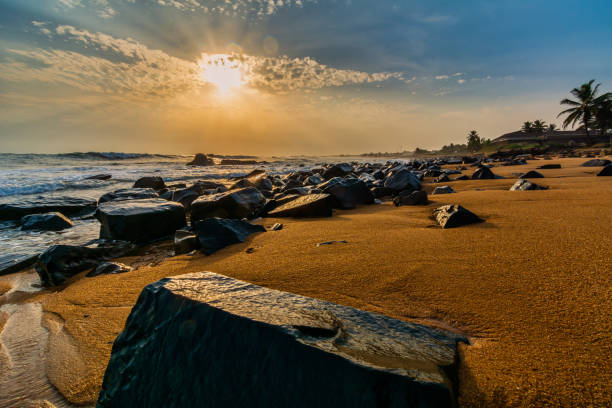 praia com areia vermelha e pedras pretas com um belo pôr do sol na cidade do congo, monróvia, libéria - liberia - fotografias e filmes do acervo