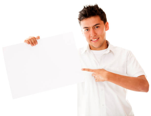 istock Man pointing at a blank banner to edit while smiling at camera 1249220012