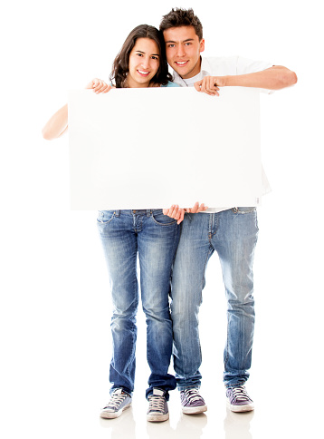 Couple holding a blank poster smiling at camera - Studio shot