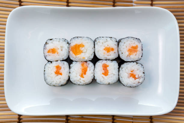istock Syake roll with salmon. Hosomaki thin rolls, simple rolls, small rolls, with cucumber. top view on a white plate. 1249221408