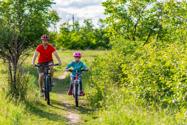 istock Dad and daughter ride bikes along the path, an active lifestyle. 1249227937