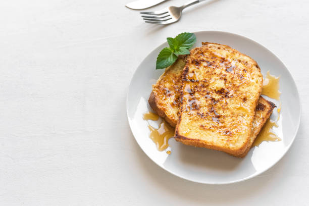 French toasts French toasts with honey syrup on plate, white background, copy space. Fried french toast for breakfast. french toast stock pictures, royalty-free photos & images