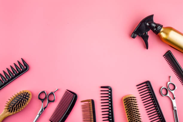 istock Hairdressing instruments. Combs, scissors and spray on pink desk from above frame space for text 1249230999