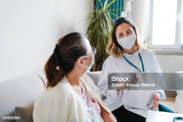 Caregiver At Home Visit During Lockdown Stock Photo - Download Image Now - Protective Face Mask, Doctor, Patient