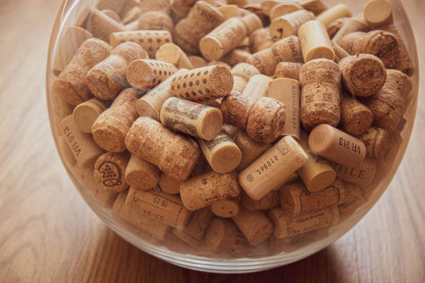 istock Bottom of big glass circle vase with wine corks inside. Wine bar backdrop 1249231963