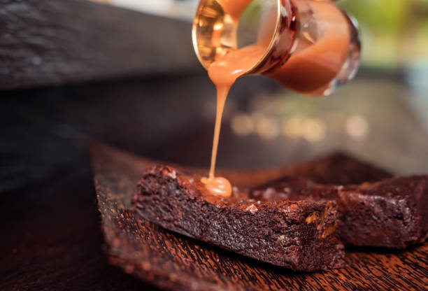 Delicious caramel brownie dessert bars on rustic dark background