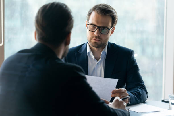 istock Serious HR manager looking at job applicant, holding cv 1249232505