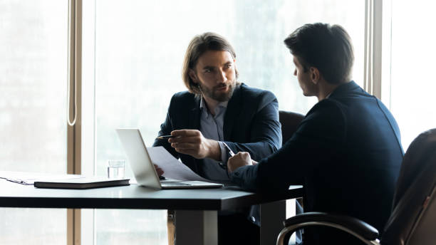 istock Confident businessman pointing at laptop screen, discussing strategy 1249232520