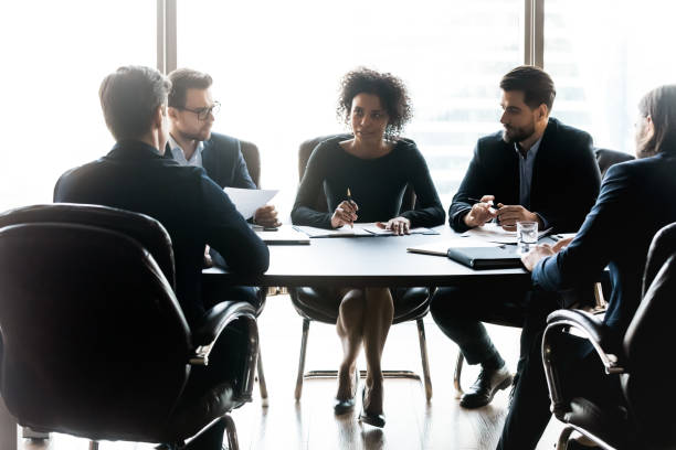 istock Diverse business partners discussing project, sitting at table in boardroom 1249232545