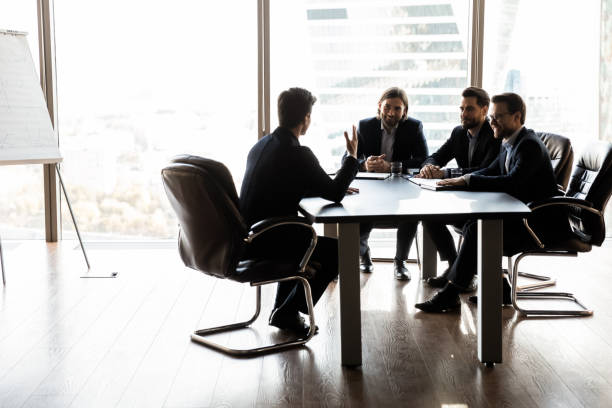 istock Happy colleagues having fun at meeting in boardroom 1249232579