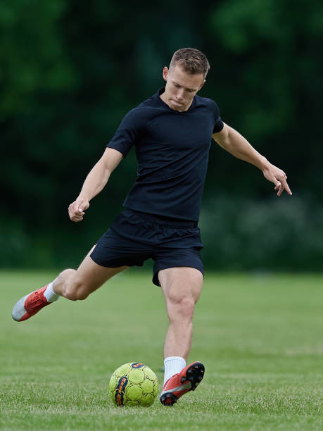 istock Football player kicking a ball 1249234905