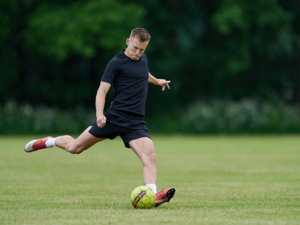 istock Football player kicking a ball 1249234919