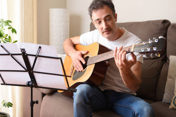 istock Adult man  learning to play guitar at home 1249237238