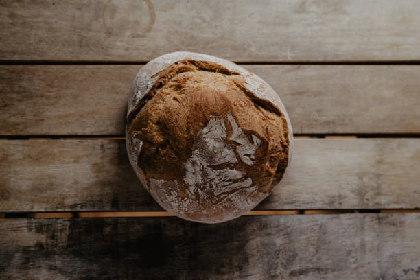 istock rustic bread, covered in flour, on wooden table 1249238333