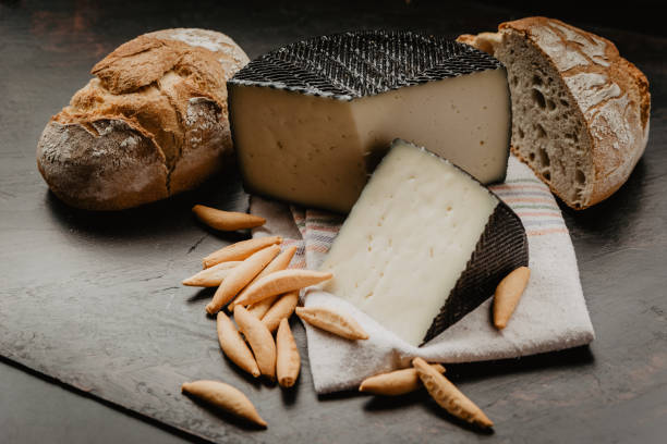 cured manchego cheese, with village bread, and breadsticks portion of half cured manchego cheese, with rustic village bread, and artisan breadsticks tapas photos stock pictures, royalty-free photos & images
