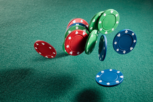 Poker chips in the air on green cloth