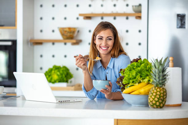 schöne frau in der küche mit laptop. - smart casual occupation casual healthy eating stock-fotos und bilder