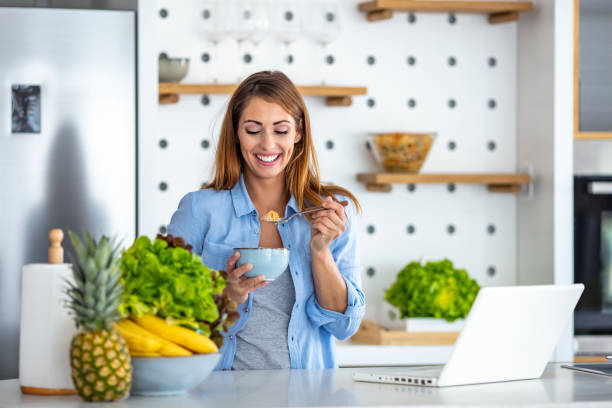 istock Beautiful young woman working on laptop while sitting at breakfast table in morning. 1249249232