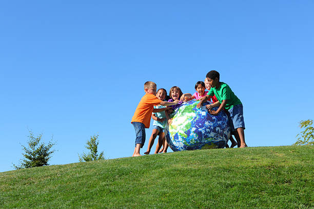 istock Group of multi-ethnic kids pushing large earth ball 124925047