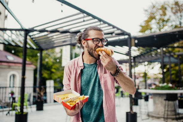 istock Young man eating fast food 1249251861