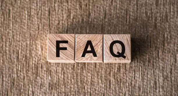 Photo of concept of FAQ word on wooden cubes on table. Closeup