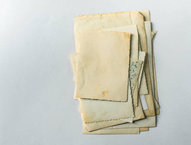 istock Folded old photos on a white table. Postcard rumpled and dirty vintage. Retro postcard 1249251928