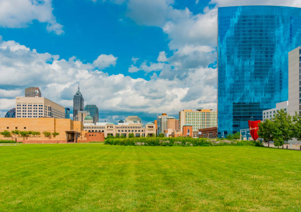 Indianapolis skyline shows a little of the capitol building in the downtown district. The capitol building is just visible in the modern Indianapolis skyline and White River State Park, Indiana landscape view of indianapolis indiana during the day stock pictures, royalty-free photos & images