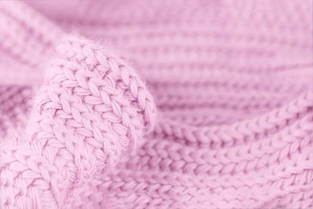 istock Pale soft pink knitted wool texture. Close up wool background. Warm and cozy. Blurred delicate background 1249253430