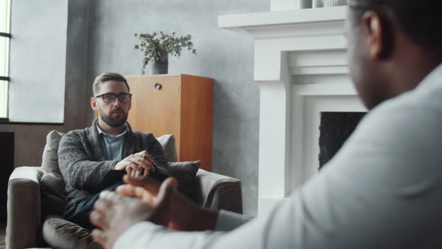 Male Psychologist Listening to Afro-American Man during Counseling Session