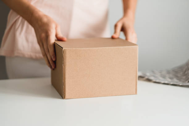 istock Woman holding a cardboard box, the parcel in hands. 1249260213