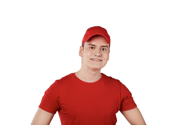 istock Young handsome confident guy from delivery service in a cap, white background. 1249261086