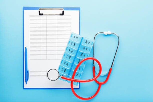 istock Doctor appointment. Stethoscope, pill box, medical documents on doctors workplace in clinic long blue banner. Concept medicine health care, research, science.Coronovirus Covid-19 test analysis form 1249262449