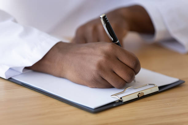 istock African American doctor filling patient form document close up 1249263106