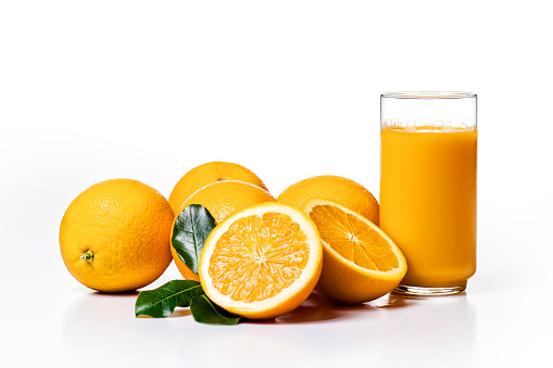 Fresh ripe orange fruit and orange juice . Tasty orange fruit juice splashing isolated on white