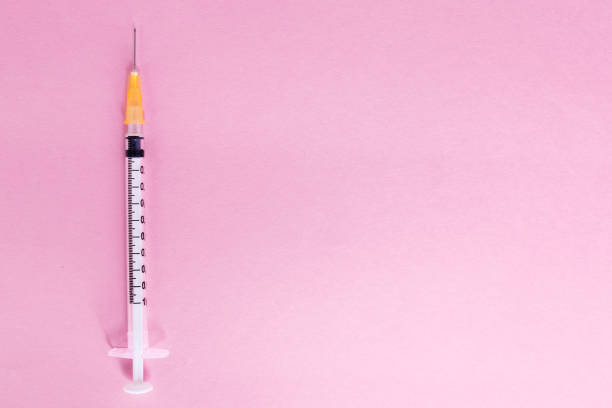 istock Top view syringe on pink background for coronavirus prevention. Covid-19 kit. Copy Space. Medical concept. 1249263333