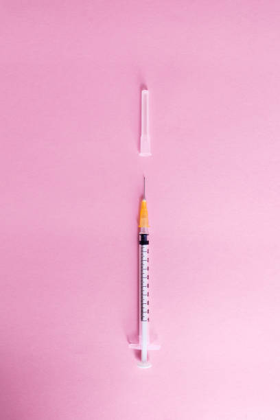 istock Top view syringe on pink background for coronavirus prevention. Covid-19 kit. Copy Space. Medical concept. 1249263910