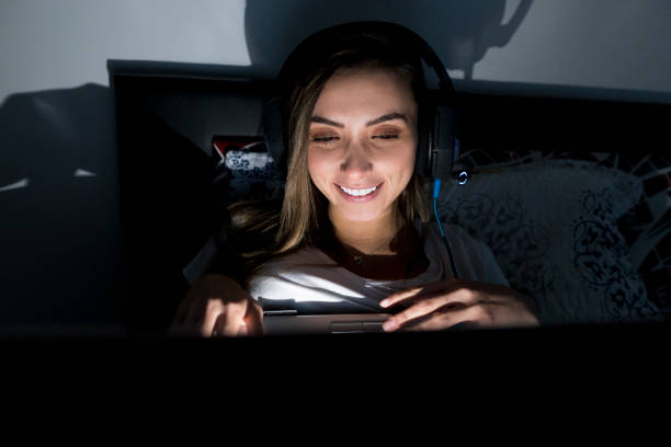 istock Latin woman has a call through her computer lying on her bed 1249267998