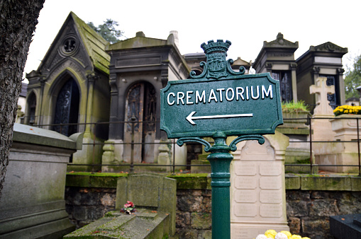 A direction sign in a cemetery, which gives the direction of a crematorium for a funeral cremation and funeral service.