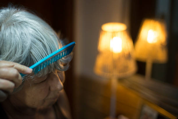 istock Senior lady combing hair preparing for haircut in home quarantine 1249278113