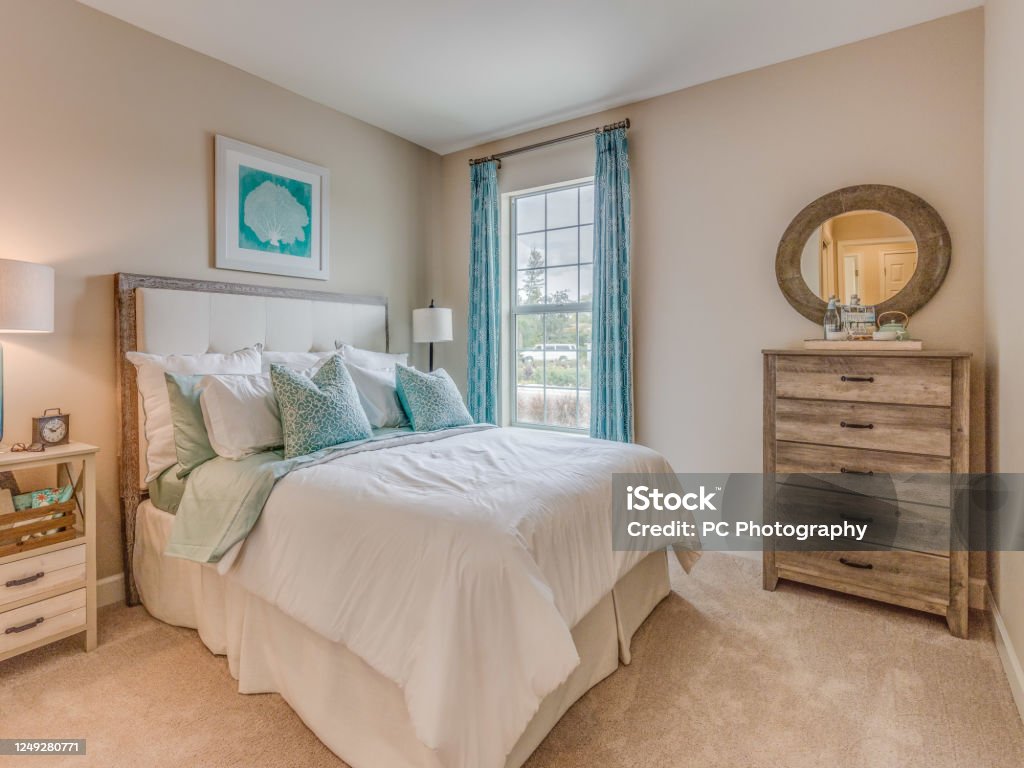 Bedroom with turquoise accents Light colors and natural wood furniture Bedroom Stock Photo