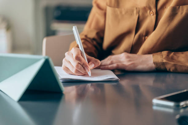istock Unrecognizable Businesswoman Writing Notes at Work, a Close Up 1249281495
