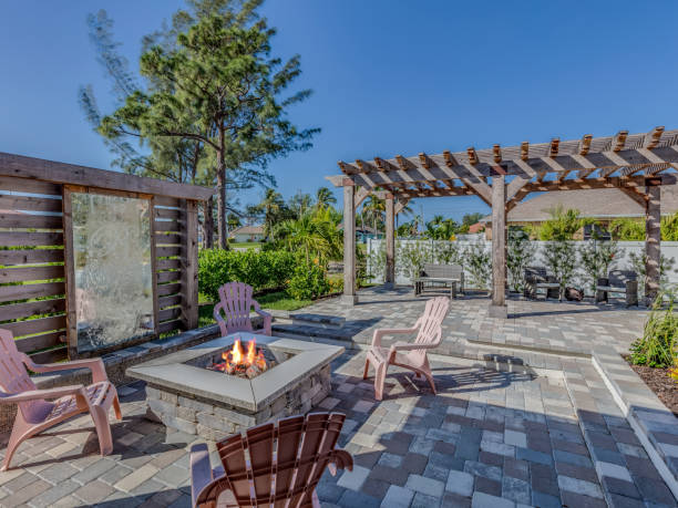 Landscaping in back of home consisting of fire pit and pergola Unique wall and stone pavers make up wonderful entertaining area fire pit photos stock pictures, royalty-free photos & images