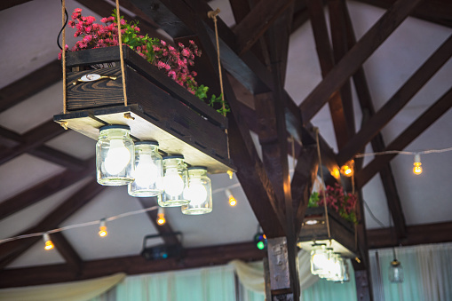 Original chandelier from jars and a flowerpot with flowers