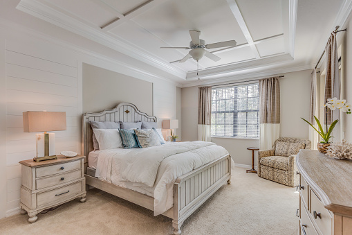 Ceiling fan and coffered ceiling are examples of decorative additions to this bedroom