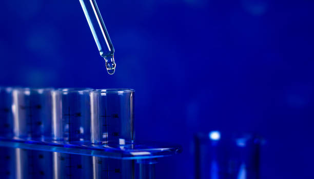 スポイトから青い背景の試験管に落ちるドロップ。 - vial laboratory test tube biotechnology ストックフォトと画像